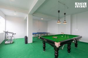 a pool table in a room with a green floor at StayVista at IRIS with Outdoor Pool & Bonfire in Dagshai