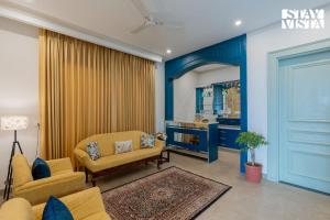 a living room with a couch and a chair at StayVista at IRIS with Outdoor Pool & Bonfire in Dagshai