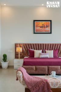a bedroom with a bed with purple sheets and a table at StayVista at IRIS with Outdoor Pool & Bonfire in Dagshai