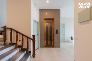 a hallway with stairs and a door in a house at StayVista at IRIS with Outdoor Pool & Bonfire in Dagshai