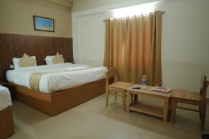 a hotel room with a bed and a table at Nova Saara Palace in Kannur