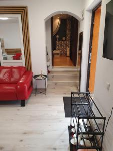 a living room with a red couch and a table at NANA"S HOUSE APARTAMENT 2 Camere,2 bai in Sibiu