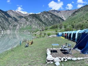 a group of tents on a hill next to a lake at Kishangangacampsgurez in Wāmpor