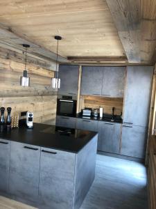 a kitchen with a black counter and wooden ceilings at Chalet - Das Schrofen in Ramsau im Zillertal