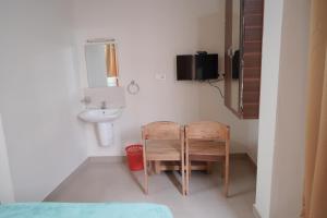 a bathroom with a sink and a chair and a mirror at Nova Saara Palace in Kannur