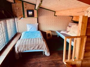 a bedroom with a bed and a staircase in a cabin at De Rietnymf in Munnekeburen