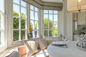a dining room with windows and a table and chairs at Haus Meerblick in Rantum