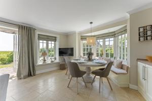 a dining room and living room with a table and chairs at Haus Meerblick in Rantum