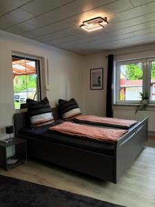 a bedroom with a large bed in a room with windows at Ferienhaus an den Eichen in Aschersleben