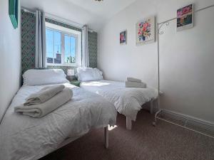 a bedroom with two beds and a window at Little Tern in Snettisham