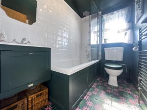 a bathroom with a toilet and a tub and a sink at Little Tern in Snettisham +3 photos