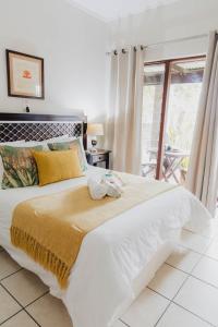 a bedroom with a large white bed with a window at Rustic Butler B&B in White River