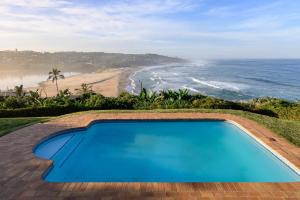 a swimming pool with a view of the beach at Shabby View Beach House in Southbroom