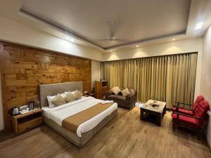 a bedroom with a large bed and a couch at Barog Heights in Barog