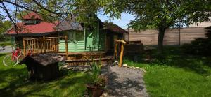 a green house in a yard with a tree at Nuit insolite, repas autour du feu piscine sauna jaccuzi in Azerailles