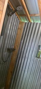 a metal wall with a shower in a house at Nuit insolite, repas autour du feu piscine sauna jaccuzi in Azerailles