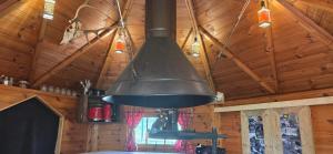 a large black bell hanging from the ceiling of a cabin at Nuit insolite, repas autour du feu piscine sauna jaccuzi in Azerailles +27 photos