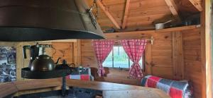a kitchen with a stove in a log cabin at Nuit insolite, repas autour du feu piscine sauna jaccuzi in Azerailles