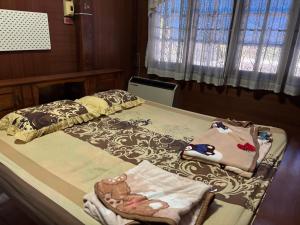ein Schlafzimmer mit einem Bett, auf dem Handtücher liegen in der Unterkunft SP Home at Maesot in Mae Sot