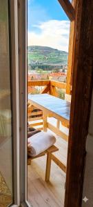 a room with a table and a bench on a balcony at Bosnian Pyramid Glamping in Visoko