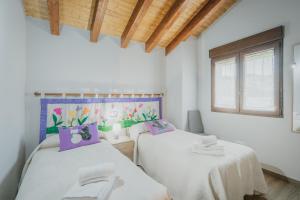 two twin beds in a room with a window at El Trillo in Marlín