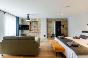 a bedroom with two beds and a couch at Johan Suites & Spa in Kuressaare