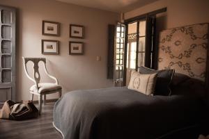 1 dormitorio con 1 cama, 1 silla y 1 ventana en Hotel MasClara, en Villa de Leyva