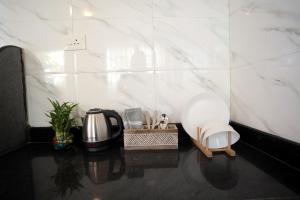 a kitchen with white marble walls and a coffee maker at Wonderland Mandrem in Mandrem
