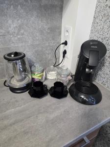 a counter top with a coffee maker and a blender at Graudu apartment in Riga