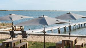 a group of tables and umbrellas on a beach at The Inn Spot in Hampton Bays