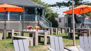 a group of tables and chairs with orange umbrellas at The Inn Spot in Hampton Bays