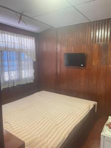 ein Schlafzimmer mit Bett und Flachbildfernseher in der Unterkunft SP Home at Maesot in Mae Sot