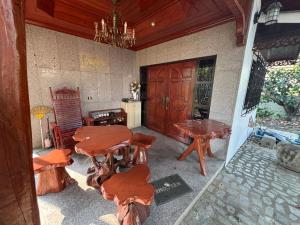 ein Raum mit Holztischen und -stühlen und einer Tür in der Unterkunft SP Home at Maesot in Mae Sot
