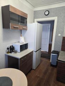 a kitchen with a white refrigerator and a microwave at Graudu apartment in Riga