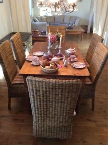 a wooden table with chairs and a candle on it at Kapitänshaus, Hausteil in Oevenum