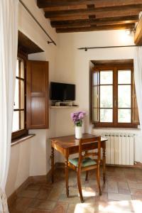 a room with a wooden table with flowers on it at L'Arcadia in Pietrasanta