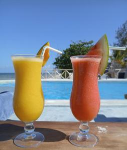 two drinks sitting on a table next to each other at 1Zi Beachfront Resort in Paje