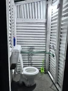 a small bathroom with a toilet in a corrugated at Kishangangacampsgurez in Wāmpor