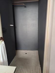 a bathroom with a shower stall with a tiled floor at 1054 Holiday Home in Kasane Airport