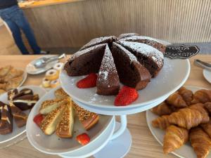 a plate of cakes and pastries on a table at Hotel Junior by OasiGroup Hotels in Rimini