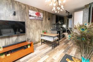 a living room with a television and a table at Charming Duplex Mauritius' Little Venice in Terre Rouge