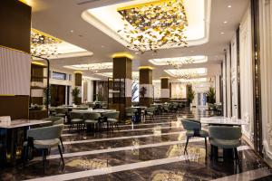 a restaurant with tables and chairs and a chandelier at Mustafa Hotel in Samarkand