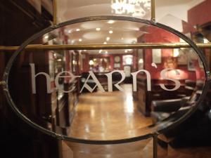 a mirror in front of a store with the wordsarma at Hearns Hotel in Clonmel