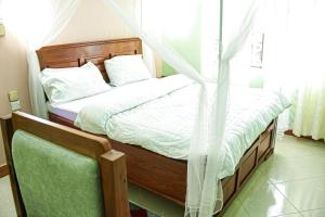 a bedroom with a bed with a canopy at JK Maasai Hotel in Wasso