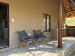two chairs sitting on the porch of a house at Shiandi Cottage in Hoedspruit +1 photo