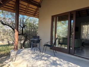 a patio with a table and chairs on a porch at Shiandi Cottage in Hoedspruit