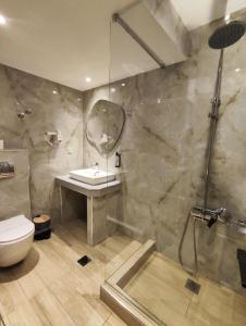 a bathroom with a shower and a sink and a toilet at Hotel Avra in Karditsa +74 photos
