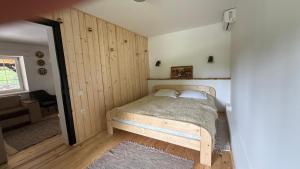 a bedroom with a bed in a room with wooden walls at Три сосни in Kosiv