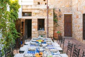 a long table with plates of food on top of it at Vasilikos Mansion - Captains Residences in Lindos