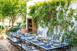 a long table with chairs and a blue and white table at Vasilikos Mansion - Captains Residences in Lindos